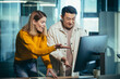© Liubomir - Employees of the IT company look at the computer monitor in surprise, an Asian man and a woman work in a modern office