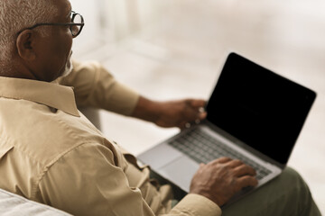 Wall Mural - Unrecognizable Senior African Man Using Laptop With Blank Screen Indoors