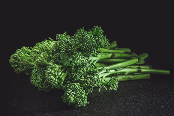 Fresh bimi vegetable on a dark table. Raw baby broccoli