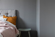 © Ulrika Kestere - Bed with gray headboard by a dark grey wall