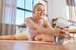 sport, fitness and healthy lifestyle concept - smiling teenage girl exercising on yoga mat and stretching leg at home