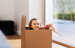 © Syda Productions - childhood, leisure and moving concept - little baby girl sitting inside cardboard box at home