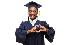 Education, Graduation And People Concept - Happy Graduate Student Woman In Mortarboard And Bachelor Gown Showing Hand Heart Gesture Over White Background