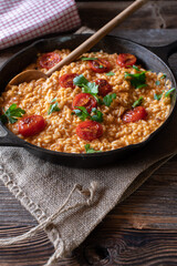 Wall Mural - Risotto with tomatoes and parmesan cheese in a cast iron pan