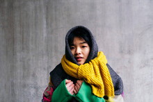Young Woman Wearing Scarf In Front Of Wall
