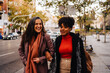 © ADDICTIVE STOCK - Smiling women walking on city street