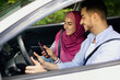 © Prostock-studio - Young Muslim Spouses Riding Car And Using Smartphone Together, Through Window Shot