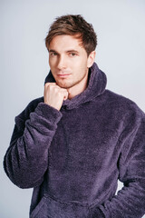 Wall Mural - Portrait of a young man in purple sweatshirt with hood on a white background. Copy, empty space for text