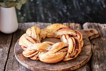 Sticker - Cinnamon bun wreath. Brioche. Side view, wooden background, coffee, cocoa powder, yeast buns.