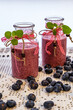 Two bottles decorated with ribbons of delicious healthy yoghurt, smoothie, blueberry smoothie