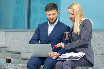 Wall Mural - successful businessmen man and woman with documents and laptop in hands discuss business projects