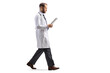 © Ljupco Smokovski - Full length profile shot of a doctor walking and looking at a document