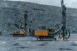 © CjVitoS - Drilling rig in an open pit in the evening.