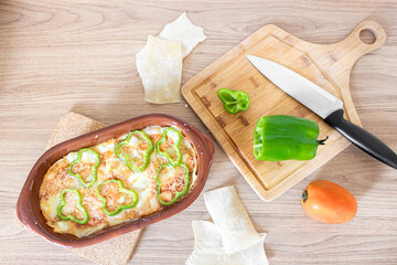 Homemade lasagna for two. Pasta, tomato, bell pepper at wooden table. Flat lay, top view.