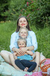 © Olha Tsiplyar - Happy mother and two children have picnic in summer park. Family, vacation and summer season concept