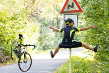 A Falling Cyclist Bumps Into A Road Sign Warning About Road With Turns.