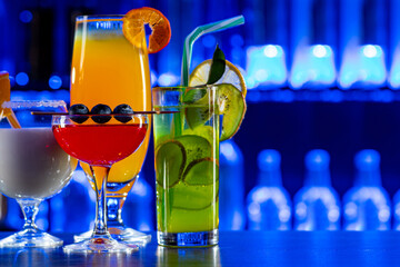 Set of coctails on bar counter in a restaurant, pub. Collection of fresh juice alcoholic drinks. Cooler beverage at nightclub on dark background