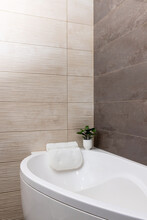 Pastel Beige Color Bathroom With White Bathtub And Pillow And Porcelain Glazed Stoneware Tile Marble Walls 