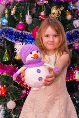 Wall Mural - A beautiful elegant girl near the Christmas tree in the New Year