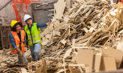 Engineer Standing to work with tablet Machines in the recycling industryl worker indoors in factory.Staff  working in an industrial factory.African  and asian Woman Engineer working and smile