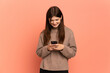 © luismolinero - Young Ukrainian girl isolated on pink background sending a message or email with the mobile