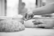 © dsheremeta - women's hands make an incision on a round dough before baking bread.