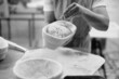 © dsheremeta - Baker woman sprinkles flour on the shaped loaves, rustic style, bread before baking, rustic whole grain bread.