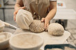 © dsheremeta - Female baker prepares bread for baking in the oven.