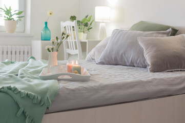 Poster - cup of coffee on wooden tray on bed with flowers and candles