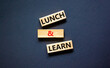 © Dzmitry - Lunch and learn symbol. Concept words Lunch and learn on wooden blocks. Beautiful black table black background. Copy space. Business, educational and lunch and learn concept.