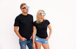 © Kaspars Grinvalds - Woman and man wearing casual black t-shirts, mockup for t shirt design
