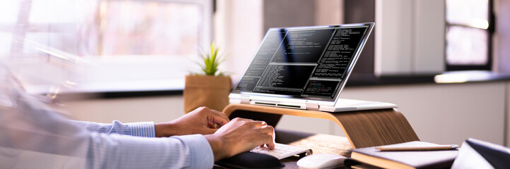 African American Coder Using Computer At Desk