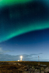 northern lights displaying above grotta island lighthouse in the icelandic capital, reykjavík