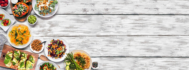 Wall Mural - Healthy plant based low carb meal corner border. Top view over a white wood banner background. Cauliflower flatbread and steak, vegetable noodles, kale salads, avocados, sweet potatoes. Copy space.