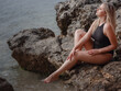 © Olena_Molchanova - Portrait of attractive blonde woman with long hair posing on rocky beach.