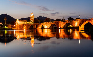 Wall Mural - church at the end of the Roman bridge of Ponte de Lima, in Minho, Portugal. Blue hour.