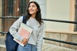 © Krakenimages.com - Young middle east student girl smiling happy holding book at the city.