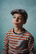 portret młodego chłopaka w czapce na niebieski tle