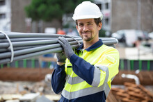 Construction Worker On Site Holding Pipe
