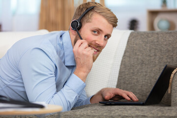 young man sitting in sofa and using laptop