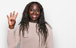 © Krakenimages.com - Young african woman wearing wool winter sweater showing and pointing up with fingers number four while smiling confident and happy.