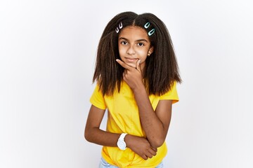 Wall Mural - Young african american girl standing over white isolated background looking confident at the camera with smile with crossed arms and hand raised on chin. thinking positive.