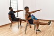 © Krakenimages.com - Young african american couple training using chair at sport center.