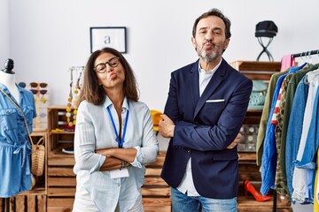 Poster - Two hispanic people working as manager at retail boutique looking at the camera blowing a kiss being lovely and sexy. love expression.