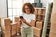 © Krakenimages.com - Middle age hispanic woman smiling confident using smartphone at new home