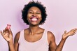 Young african american woman holding menstrual cup celebrating victory with happy smile and winner expression with raised hands