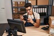 © Krakenimages.com - Young hispanic man ecommerce business worker using professional camera at office