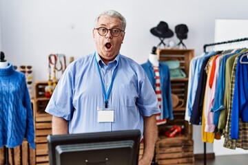 Canvas Print - Senior man with grey hair working as manager at retail boutique afraid and shocked with surprise expression, fear and excited face.