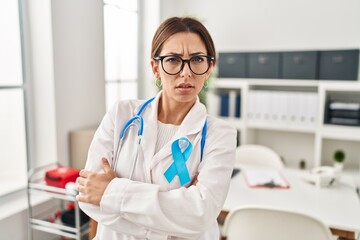 Wall Mural - Young brunette doctor woman wearing stethoscope at the clinic skeptic and nervous, disapproving expression on face with crossed arms. negative person.