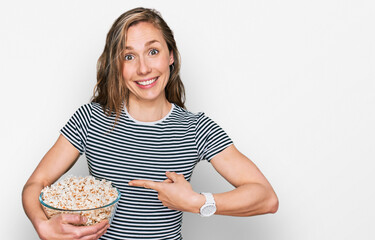 Poster - Young blonde woman eating popcorn smiling happy pointing with hand and finger